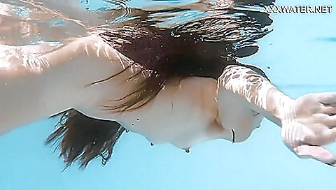 Beautiful brunette gets naked and gets off on her back